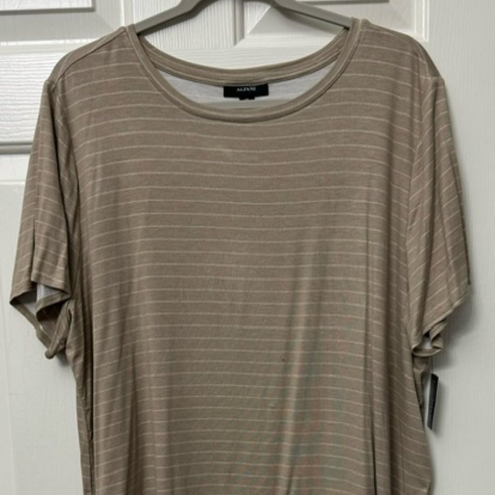 A taupe brown short-sleeve t-shirt with thin horizontal white stripes, hanging on a gray hanger against a white paneled door.