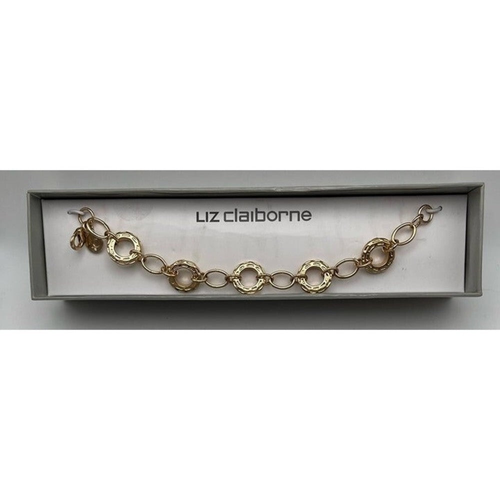 A gold-tone chain bracelet with textured circular links, presented inside a light gray box with the brand name 'luz claiborne' printed on the insert.
