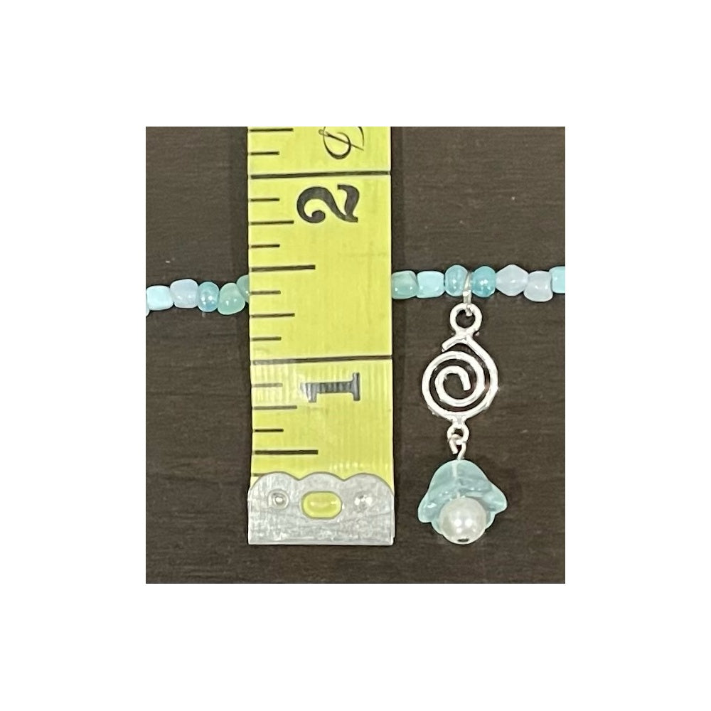 Pendant view of handmade blue necklace with a silver spiral charm and pearl