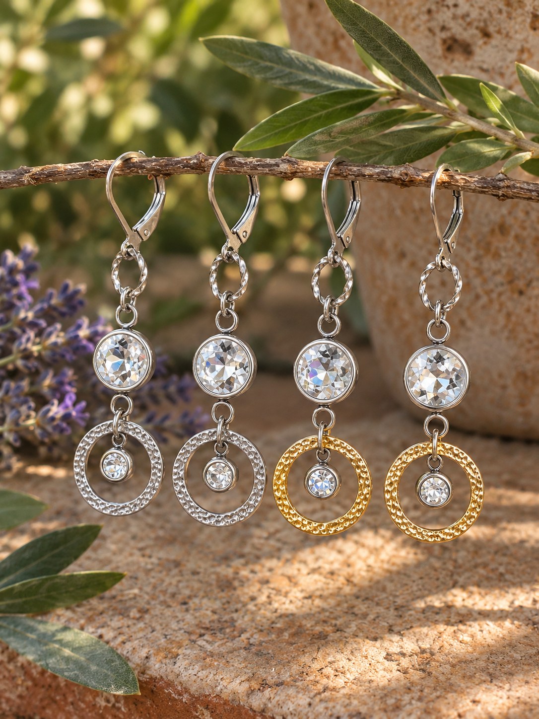 Silver and gold Venus Sunlight rhinestone dangle earrings with textured circular drops displayed outdoors.