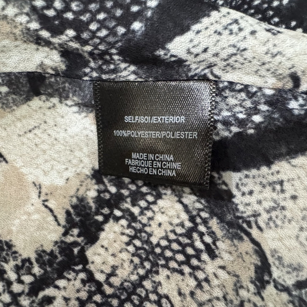 Clothing material tag view on WAYF top with a patterned surface and a label indicating material and origin.