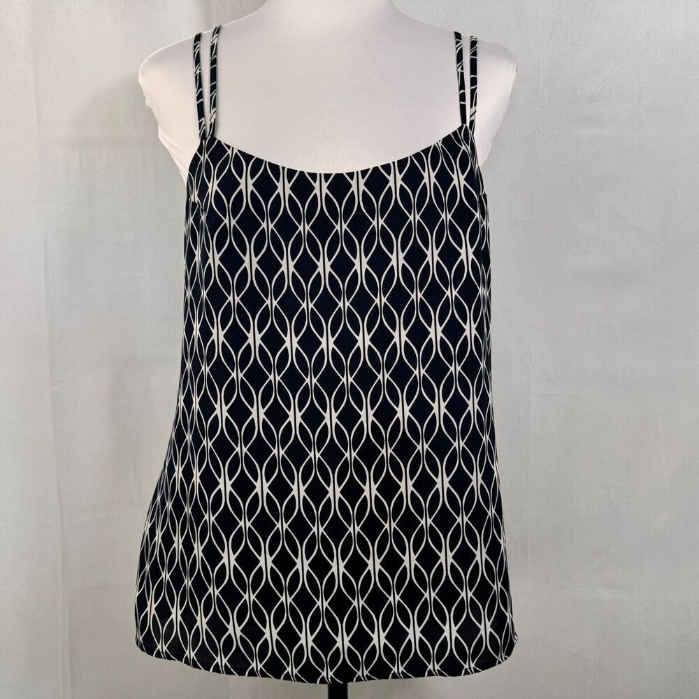 A sleeveless camisole top with thin straps, featuring a black and white geometric interlocking diamond pattern, displayed on a white mannequin torso against a light gray fabric backdrop.
