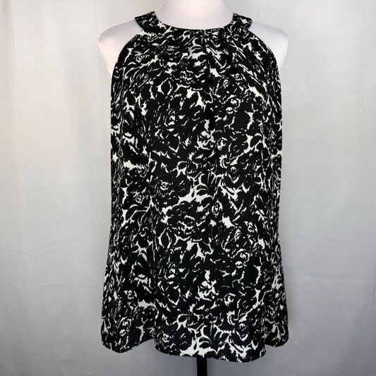 A sleeveless halter-neck top with a black and white abstract floral pattern, displayed on a white mannequin torso against a light gray fabric backdrop.