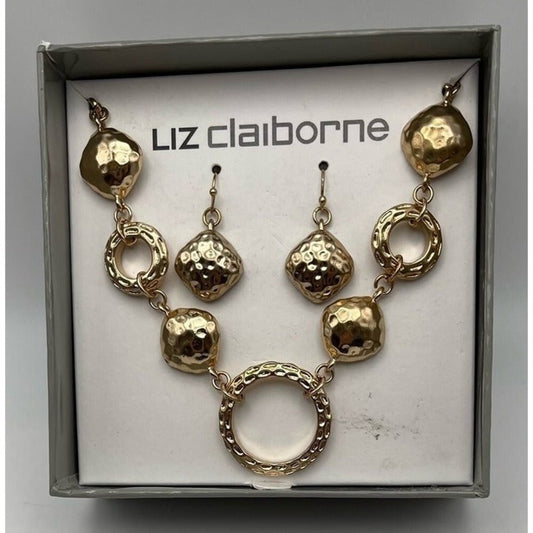 A gold jewelry set by Liz Claiborne, including a necklace and matching earrings, displayed inside its original gray box with a white insert.