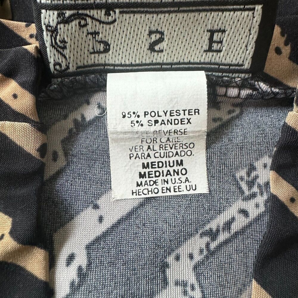 Close-up of a garment's interior neck label and patterned lining. The white care tag reads '75% POLYESTER 25% SPANDEX' and 'MEDIUM MEDIANO MADE IN U.