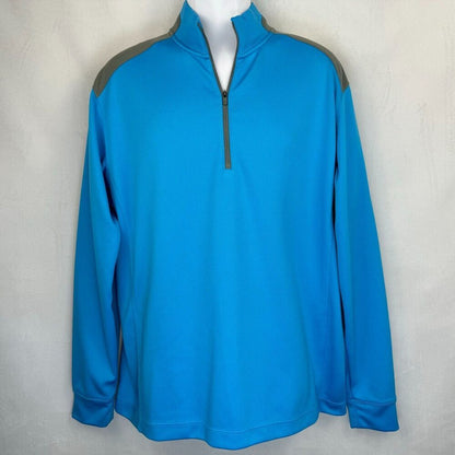 A bright blue long-sleeve quarter-zip pullover jacket with gray shoulder panels, displayed on a white mannequin torso against a light gray textured wall.