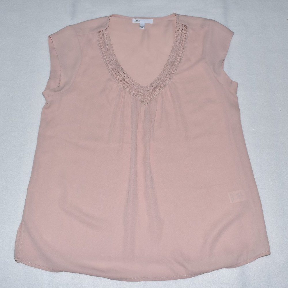 A light pink sleeveless top with a V-neckline and delicate lace trim, laid flat on a light gray background.