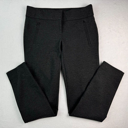 Black heathered knit pants with zippered side pockets, laid flat on a light gray textured background.