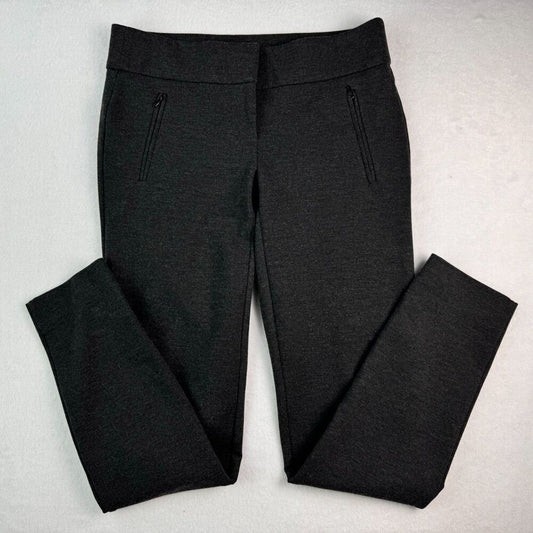 Black heathered knit pants with zippered side pockets, laid flat on a light gray textured background.