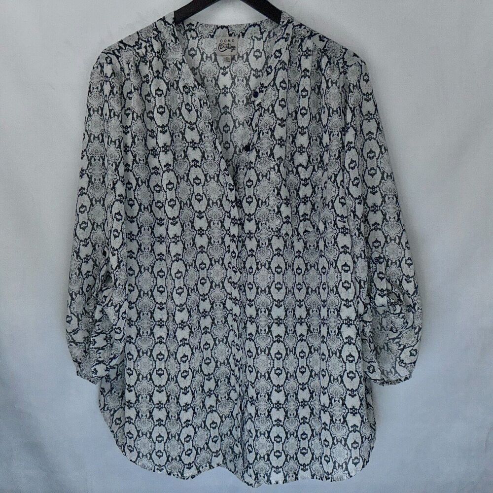 A women's long-sleeve blouse with a black and white snake print pattern, hanging on a black hanger against a light gray fabric backdrop.