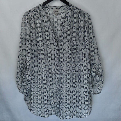 A women's long-sleeve blouse with a black and white snake print pattern, hanging on a black hanger against a light gray fabric backdrop.