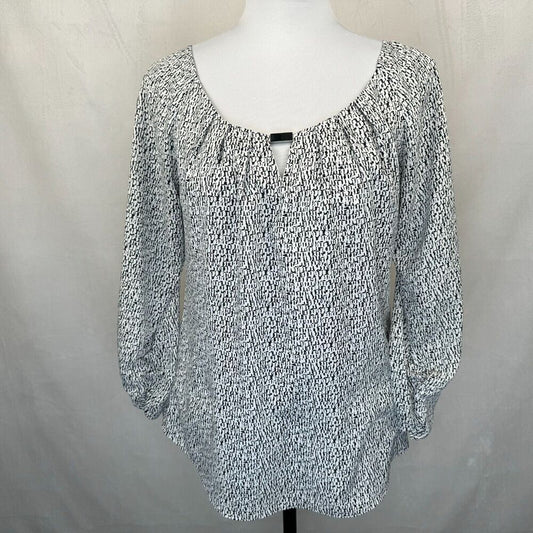 A women's long-sleeve top with a black and white speckled or marled pattern, displayed on a white mannequin torso against a neutral light gray fabric backdrop.