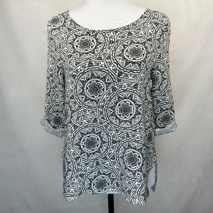 A black and white patterned top with three-quarter sleeves displayed on a white mannequin torso against a light gray fabric backdrop.