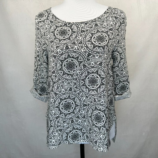 A black and white patterned top with three-quarter sleeves displayed on a white mannequin torso against a light gray fabric backdrop.