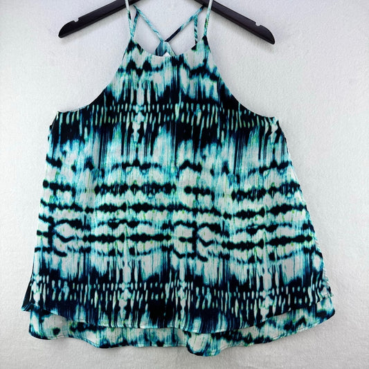 A sleeveless halter-style top with a teal, black, and white tie-dye pattern, hanging on a black hanger against a white textured wall.