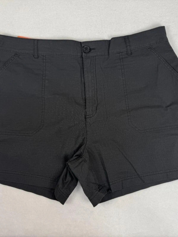 Black chino shorts with a button closure and belt loops, laid flat on a light gray textured surface.