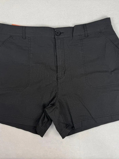 Black chino shorts with a button closure and belt loops, laid flat on a light gray textured surface.