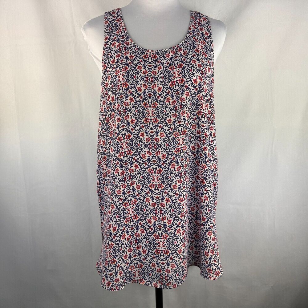 A sleeveless scoop-neck shift dress with a dense red, white, and navy floral pattern, displayed on a white mannequin torso against a light gray fabric backdrop.