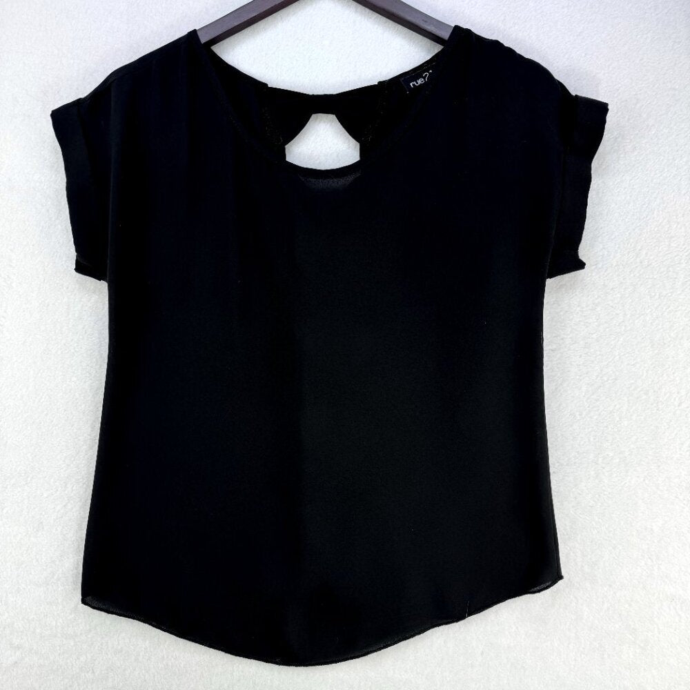 A black short-sleeve top with a keyhole cutout at the neckline, hanging on a dark hanger against a textured white wall.