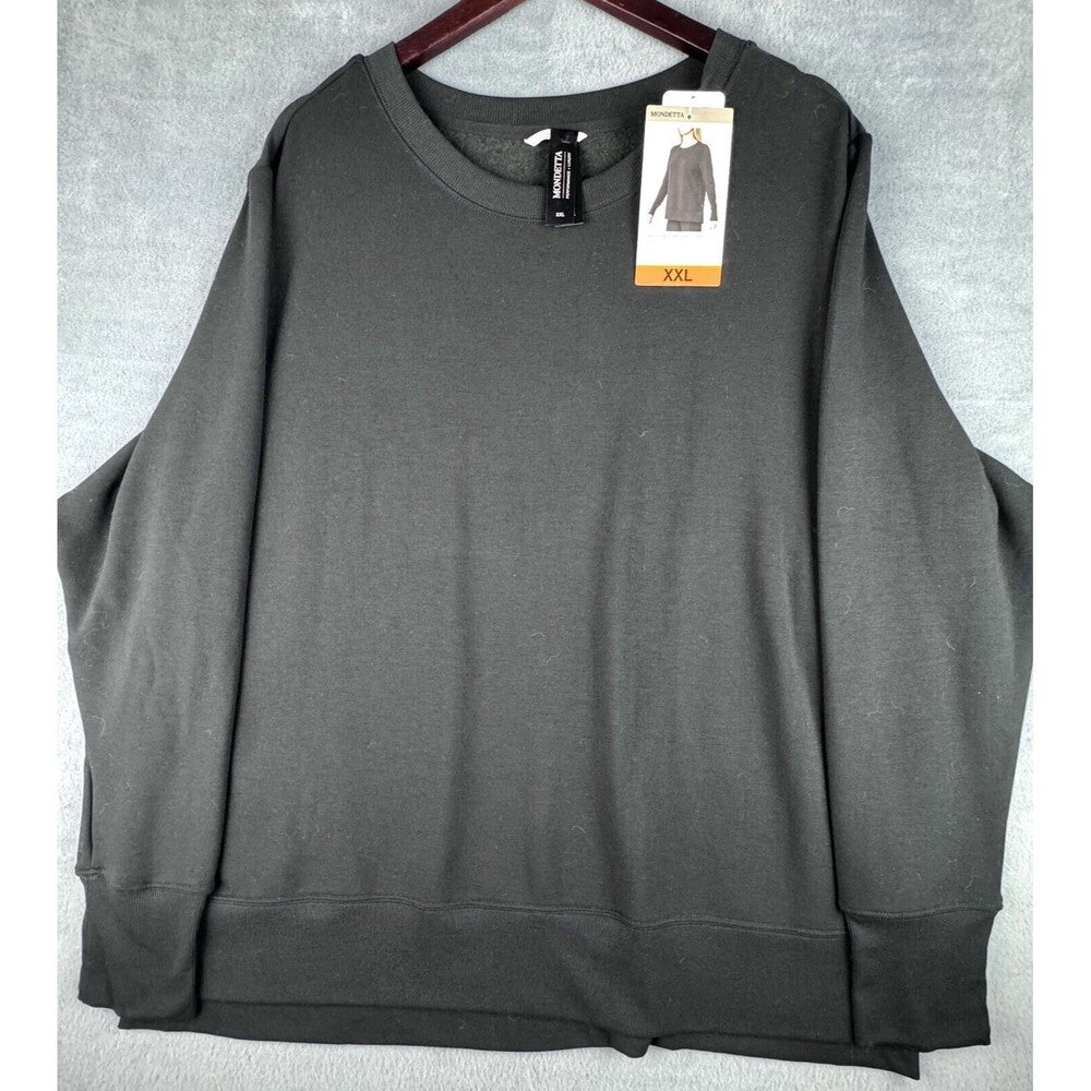 A dark gray oversized crewneck sweatshirt with wide sleeves, hanging on a wooden hanger against a gray textured background. The sweatshirt has a retail tag attached near the collar indicating size XXL.