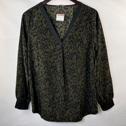 A women's long-sleeve blouse with a dark olive green and black leopard print, featuring a V-neckline with dark ribbed trim and dark cuffs, hanging on a wooden hanger against a white background.