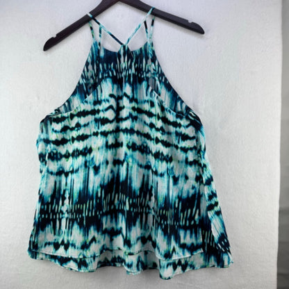 A sleeveless halter-style top with a teal, blue, and black tie-dye pattern, hanging on a black hanger against a white textured wall.