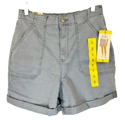 Light blue denim shorts with a button closure, front pleats, and rolled cuffs, shown with a yellow Gildan size tag attached on a white background.