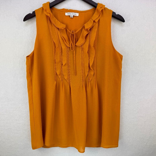 A sleeveless mustard yellow blouse with a ruffled collar and tie-front detail, hanging on a black hanger against a textured white wall. The brand label reads 'MADLYN'.