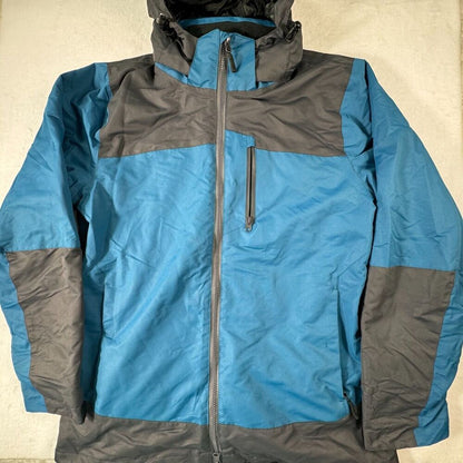 A blue and gray colorblock hooded jacket with a full front zipper and a vertical zippered chest pocket, laid flat against a light beige background.