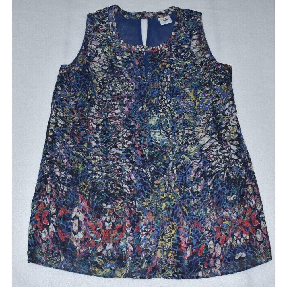 A sleeveless A-line top with a dense abstract floral and organic print in navy blue, red, pink, yellow, and white, laid flat on a light gray background.