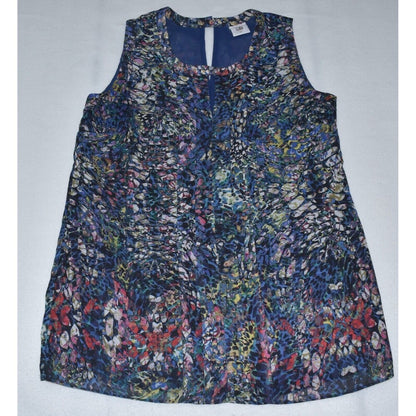 A sleeveless A-line top with a dense abstract floral and organic print in navy blue, red, pink, yellow, and white, laid flat on a light gray background.