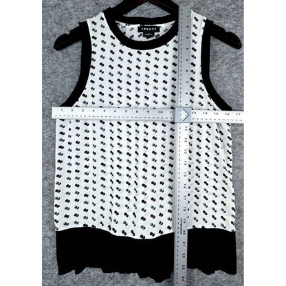 A sleeveless white knit top with a black dotted pattern, black trim, and a black ruffled hem, shown on a hanger with a measuring tape and ruler overlaid to indicate dimensions. The brand label reads 'JANE'S'.
