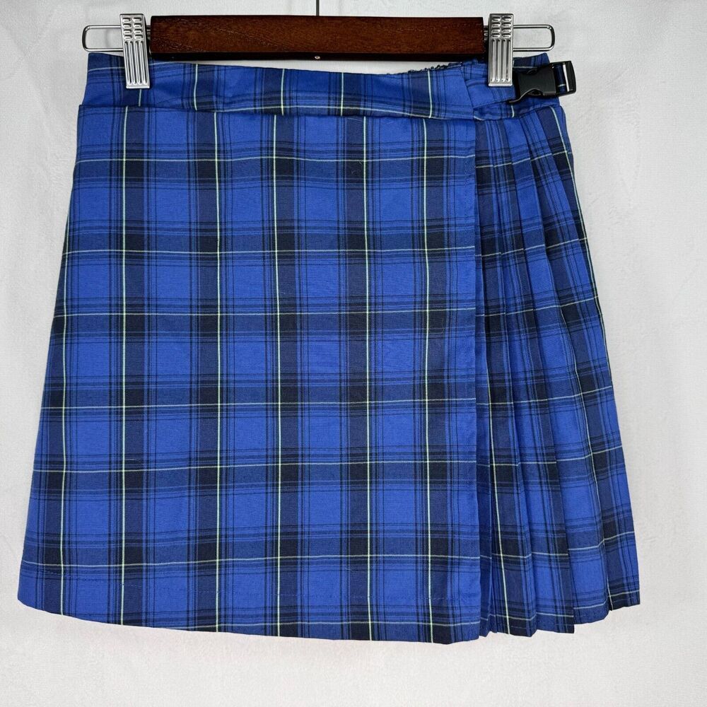 A blue plaid kilt skirt with thin white and black stripes, hanging on a wooden hanger with metal clips against a white background.