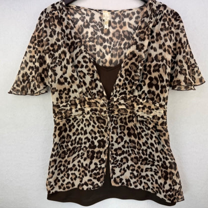 A leopard print short-sleeve blouse with a V-neckline and gathered front detail, displayed on a hanger against a light gray background.