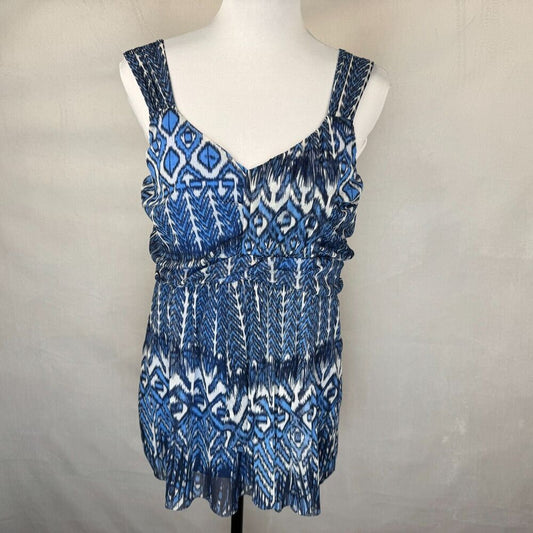 A sleeveless V-neck top with a blue and white geometric ikat pattern, displayed on a white mannequin torso against a neutral light gray background.
