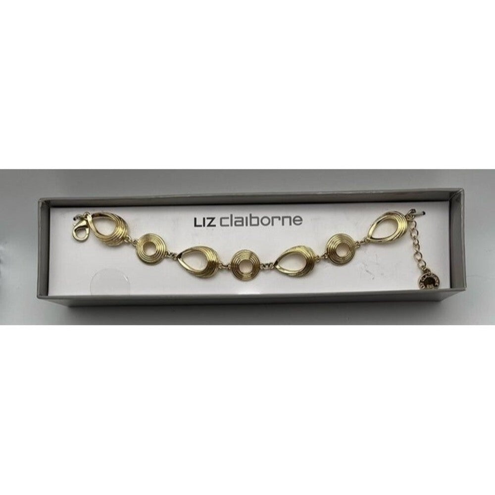 A gold-tone oval link bracelet by Liz Claiborne, displayed inside its original gray presentation box with the brand name printed on the inner card.