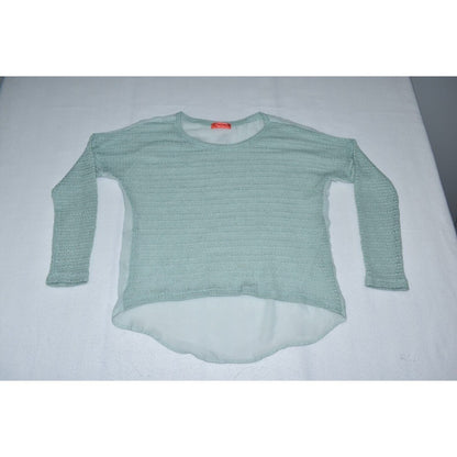 A light sage green ribbed knit long-sleeve top with a high-low hem, laid flat on a white surface.