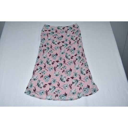 A pink skirt with a blue and dark purple floral pattern, laid flat on a white surface.