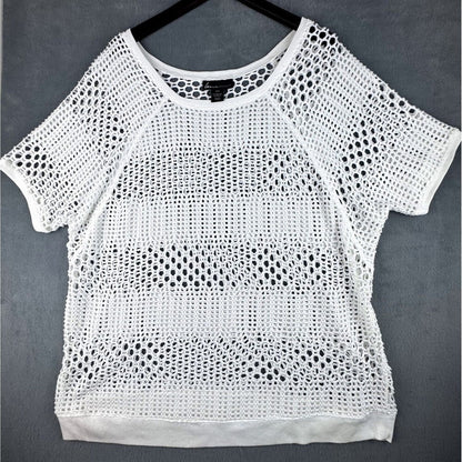 White short-sleeve crochet knit top hanging on a black hanger against a dark gray background.