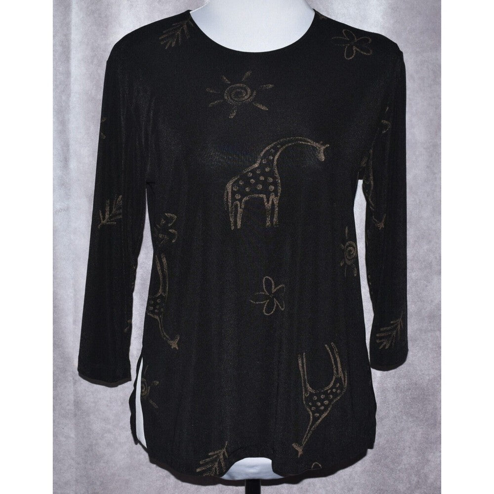 A black long-sleeve tunic top with a textured knit fabric, featuring a whimsical giraffe and sun pattern in a metallic gold or bronze color, displayed on a white mannequin torso against a gray curtain background.