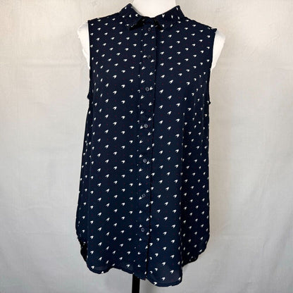 A sleeveless navy blue button-up blouse with a white geometric pattern, displayed on a white mannequin torso against a light gray fabric backdrop.