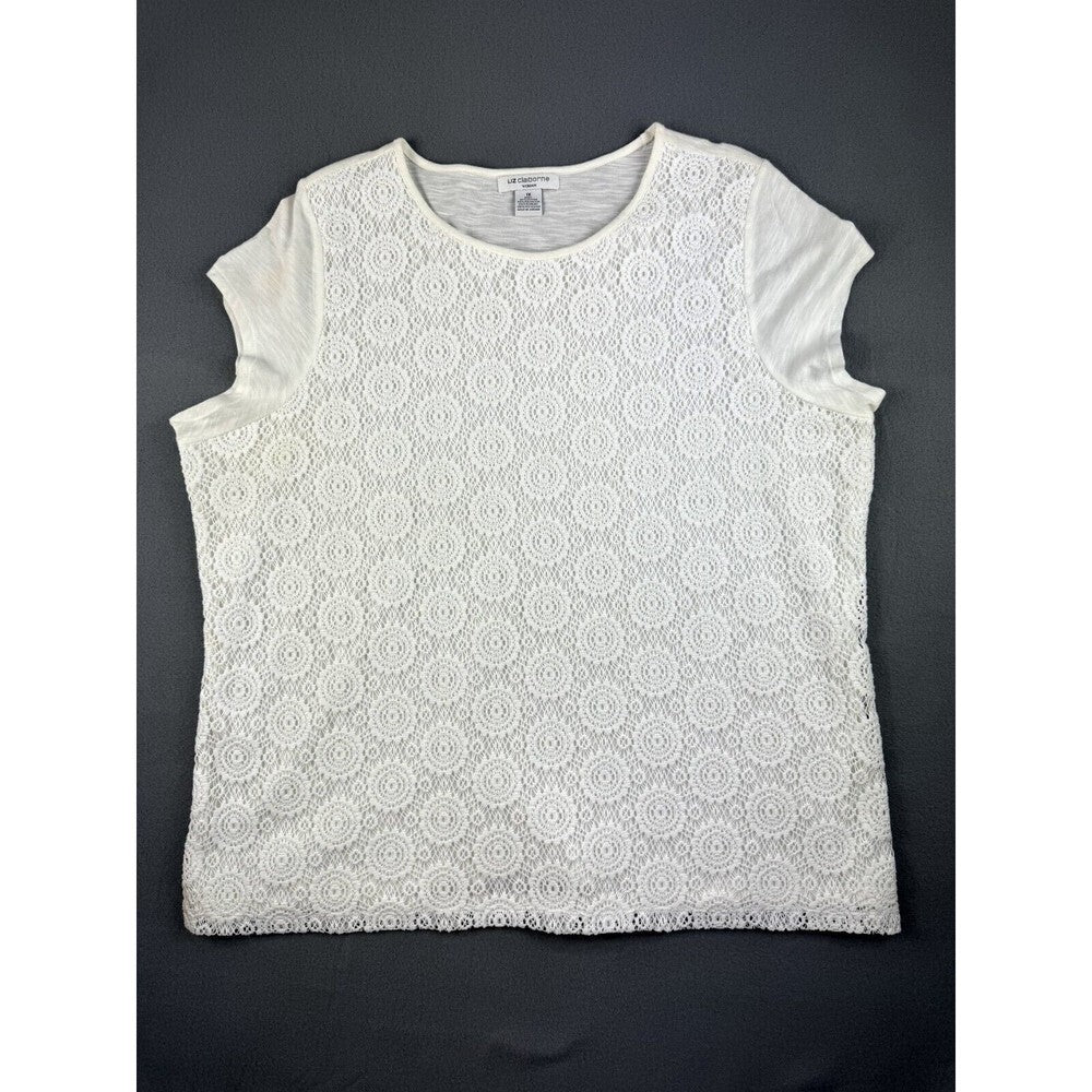 A white short-sleeve top with an all-over circular lace overlay pattern, laid flat on a dark gray background.