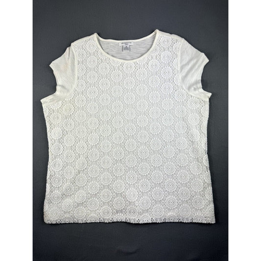 A white short-sleeve top with an all-over circular lace overlay pattern, laid flat on a dark gray background.