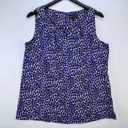 A sleeveless leopard-print top in shades of purple, blue, and black, hanging on a black hanger against a light gray textured background.