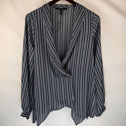 A long-sleeve wrap-style blouse with vertical navy, gray, and white stripes, hanging on a dark wooden hanger against a plain off-white fabric backdrop.