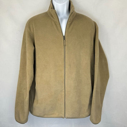 A tan zip-up fleece jacket displayed on a white mannequin torso against a light gray textured wall.