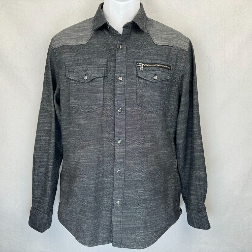 A dark gray western-style long-sleeve button-up shirt with a subtle textured weave, featuring a zippered chest pocket and two buttoned flap chest pockets, displayed on a white mannequin torso against a light gray background.