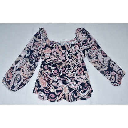 A women's long-sleeve blouse with a square neckline, featuring a swirling paisley-like abstract pattern in black, pink, and beige, laid flat on a light gray background.