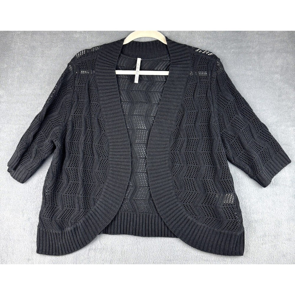 A black open-front knit cardigan sweater with three-quarter sleeves and a textured chevron pattern, laid flat on a light gray textured background.