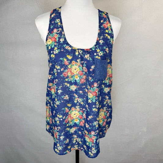 A sleeveless scoop-neck tank top with a colorful floral print on a navy blue base, displayed on a white mannequin torso against a light gray fabric backdrop.